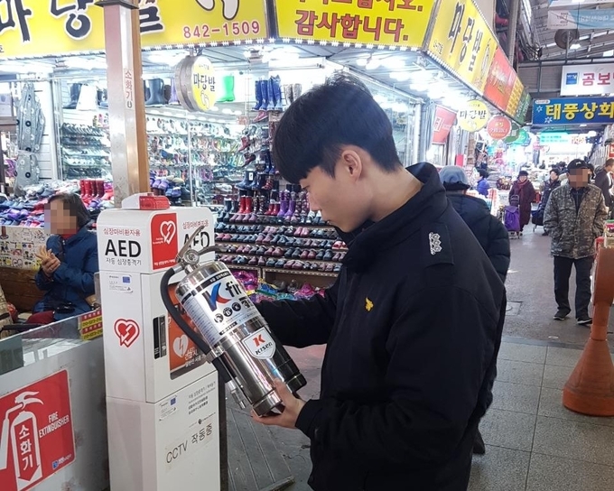 의정부소방공무원이 제일시장 내 음식점에 비치된 k급 소화기를 점검하고 있다.(사진설명)