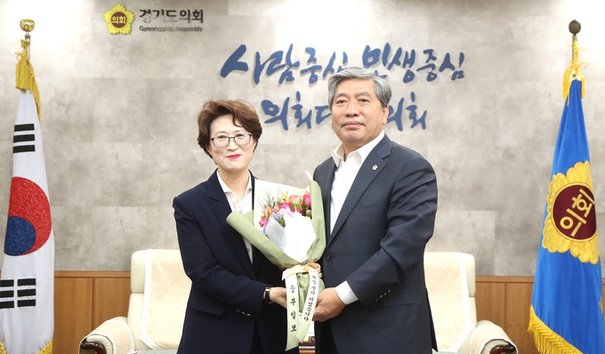 '플라워 버킷 챌린지' 캠페인에 동참한 경기도의회 송한준 의장(오른쪽쪽)이 중부일보 최윤정 대표이사(왼쪽)로 부터 꽃다발을 전달받고 기념촬영을 하고 있다.(사진설명)