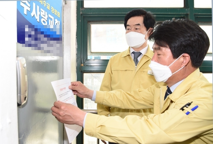 안병용 의정부시장(뒷쪽)과 이종원 의정부시보건소장(앞쪽)이 27일 코로나19 확진자가 발생한 주사랑교회를 직접 방문해 집합금지 명령 스티커를 부착하고 있다.(사진설명)