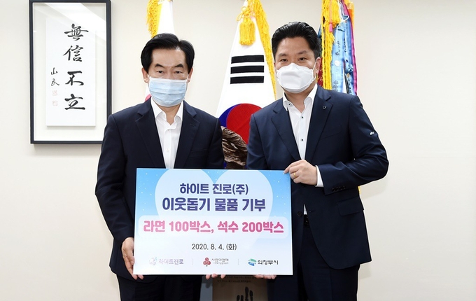 의정부시에 이웃돕기 물품을 기탁한 하이트진로(주) 방상복 경인권역장(오른쪽)이 안병용 시장(왼쪽)과 기념촬영을 하고 있다.(사진설명)