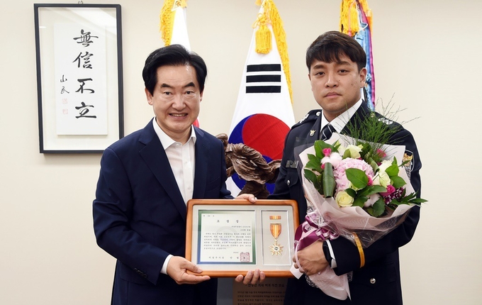 안병용 시장이 지난 5일 폭우로 수위가 높아진 중랑천에 빠져 떠내려가던 어린이를 구조한 의정부경찰서 신곡지구대 소속 고진형 경장에게 모범시민 표창장을 수여후 기념촬영하고 있다.(사진설명)