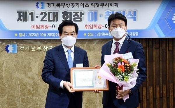 (주)운트바이오 전용수 대표(우측)가 안병용 의정부시장(왼쪽)으로부터 우수모범기업 표창장을 수상후 기념촬영하고 있다.(사진설명)