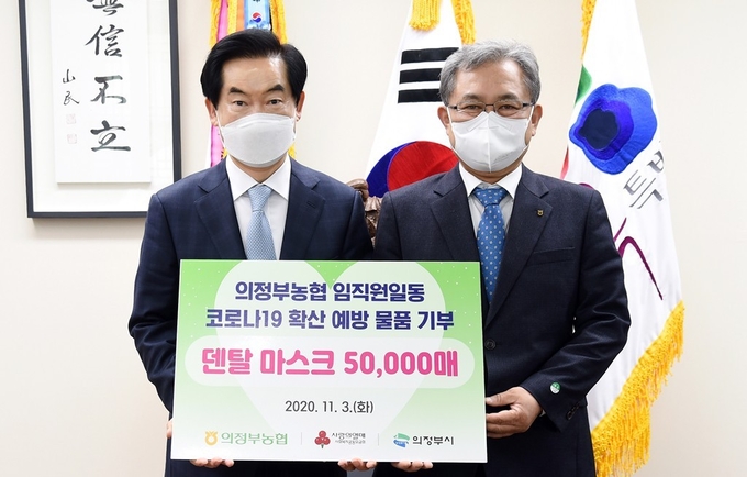 안병용 의정부시장(왼쪽)이 김명수 의정부농협 조합장(오른쪽)이 마스크 기탁식 후 기념촬영하고 있다.(사진설명)