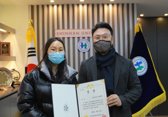 강성종 신한대학교 총장(오른쪽)이 지난 25일 민주평화통일자문회의 서울청년위원회가 주관한 ‘2020 외국인 평화통일 스피치 대회’에서 대통령 표창을 받은 몽골 출신 부랭채책씨(왼쪽, 3학년 재학중)에게 표창을 전수 후 기념촬영하고 있다.(사진설명)