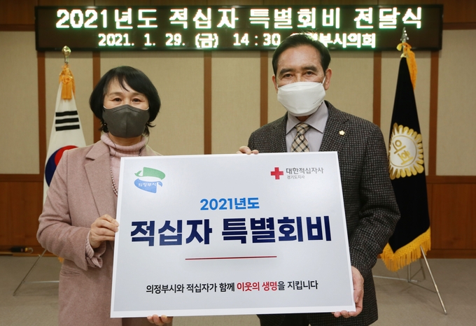 오범구 의정부시의회(오른쪽)는 지난 29일 대한적십자사 경기도지사 윤신일 회장(왼쪽)에게 2021년도 적십자 특별회비를 전달했다.(사진설명)