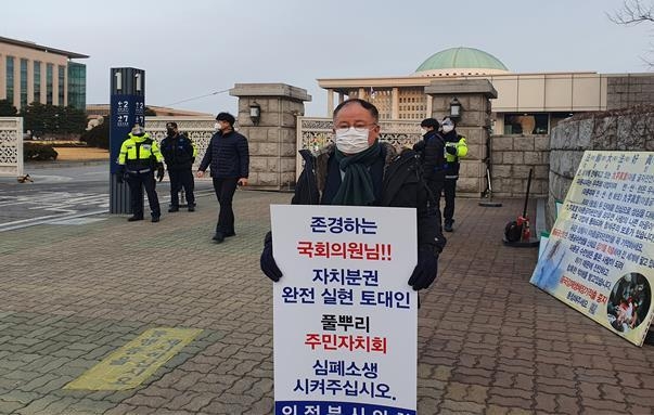 의정부시의회 김정겸 의원이 2월 16일 국회 정문 앞에서 지방자치 전부 개정안 중 '주민자치 조항' 삭제에 대한 문제점을 제기하며 1인 시위를 펼치고 있다.(사진설명)