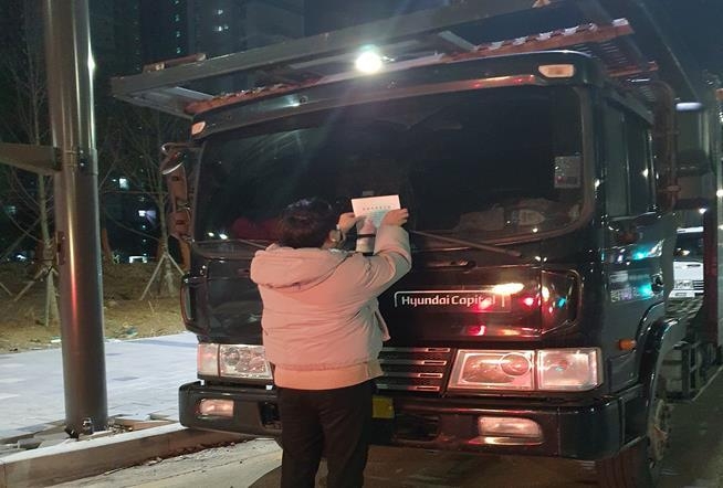 의정부시 송산3동행정복지센터 직원이 불법주차한 화물자동차를 단속하고 있다.(사진설명)