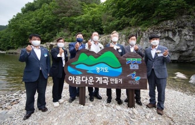 이재명 경기지사(오른쪽에서 세번째)가 지난해 5월 26일 경기도 가평군 북면 용소폭포에서 열린 '경기도 청정계곡 생활SOC' 준공식에서 정비된 계곡을 돌아본 뒤 기념촬영하고 있다.(사진설명)