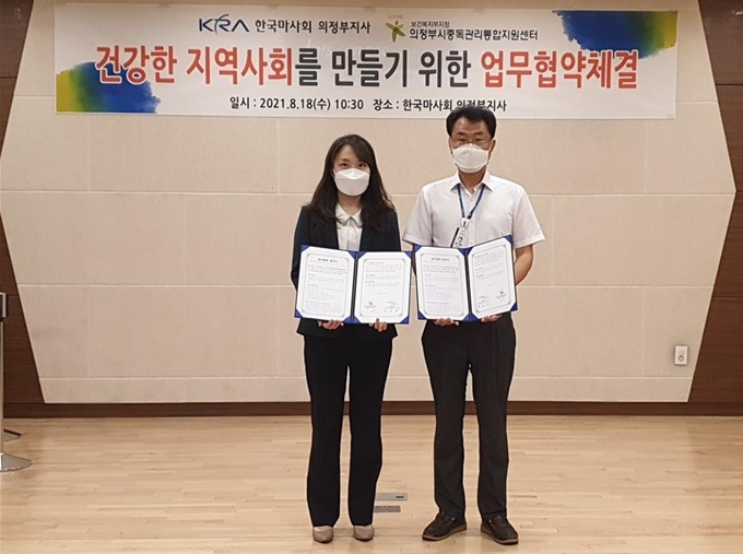 18일 한국마사회 김국연 의정부지사장(오른쪼)과 의정부시중독관리통합지원센터 이현아 센터장(왼쪽)이 업무협약 체결 후 기념촤영하고 있다.(사진설명)