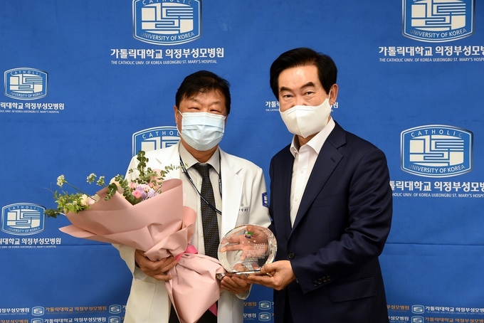 안병용 의정부시장이(오른쪽)이 박태철 의정부성모병원장(왼쪽)에게 감사패를 전달후 기념촬영하고 있다.(사진설명).