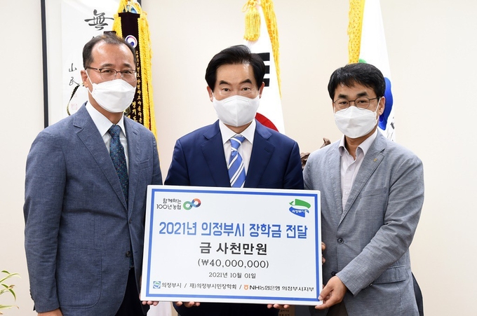 안병용 시장(가운데)이 장학금 전달식에 참석한 이시용 NH농협은행 의정부시지부장(오른쪽) 및 이상훈 의정부시민장학회 이사장(왼쪽)과 기념촬영하고 있다.(사진설명)