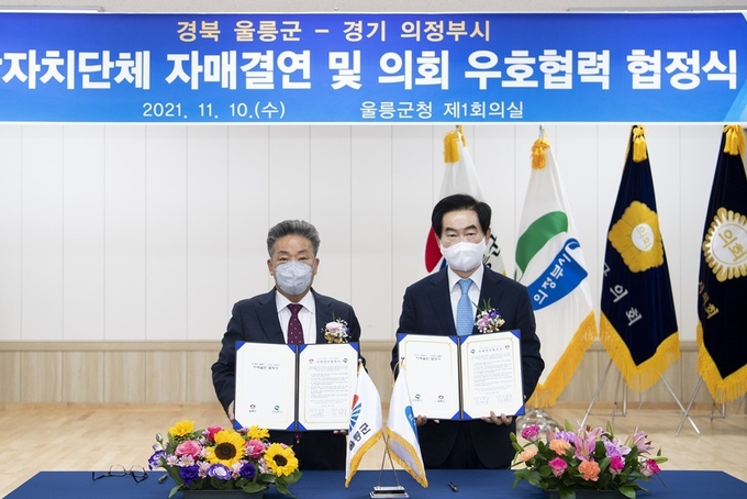 안병용 의정부시장(오른쪽)와 김병수 울릉군수(왼쪽)가 자매결연 협정을 체결 후 기념촬영하고 있다.(사진설명)