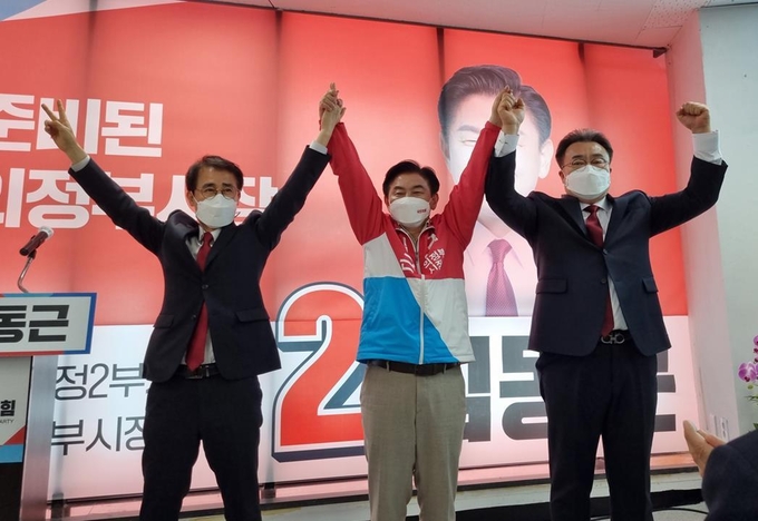 국민의힘 의정부시장 후보 경선를 함께 치렀던 구구회 후보(왼쪽)와 임호석 후보(오른쪽)가 김동근 후보를 지지하며 두 손을 번쩍 들어 올렸다.(사진설명)