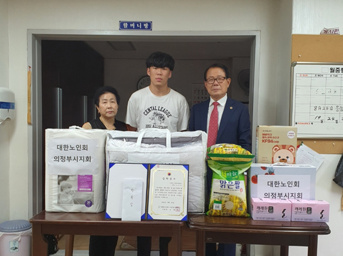 김형두 의정부시노인지회장(오른쪽)이 생필품을 전달하고 있다.(사진설명)