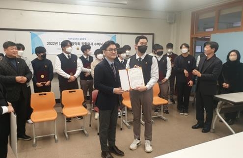 의정부고 출신인 가수 추가열이 장학금 증서를 수여후 기념촬영하고 있다.(사진설명)