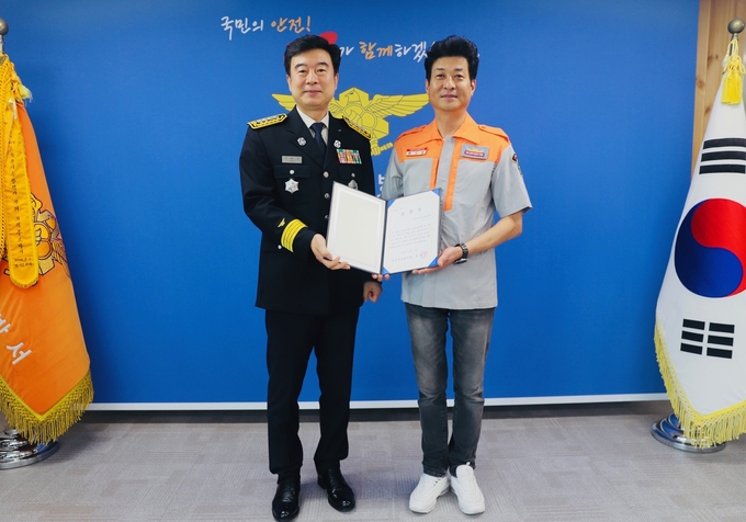 유해공 의정부소방서장(왼쪽)이 화재진압에 기여한 황인호씨(오른쪽)에게 시민 유공자 표창장을 수여했다.(사진설명)