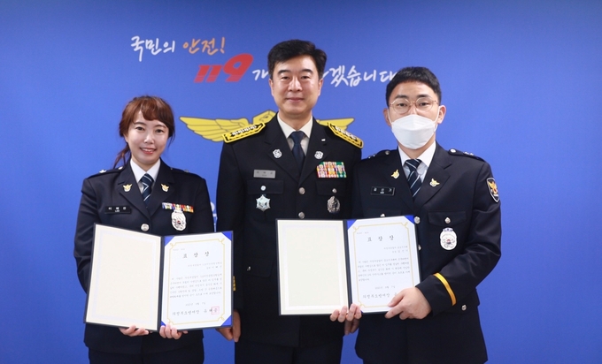 유해공 의정부소방서장(가운데)이 초기 화재진압에 기여한 112치안종합상황실 이혜진 경위(왼쪽)와 금오지구대 김신기 순경(오른쪽)에게 유공 표창장을 수여했다.(사진설명)
