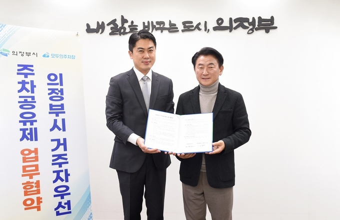 김동근 의정부시장(오른쪽)이 주택 밀집 지역 주차난 완화를 위해 주차공유서비스 업체인 (주)모두컴퍼니와 업무협약을 체결했다.(사진설명)