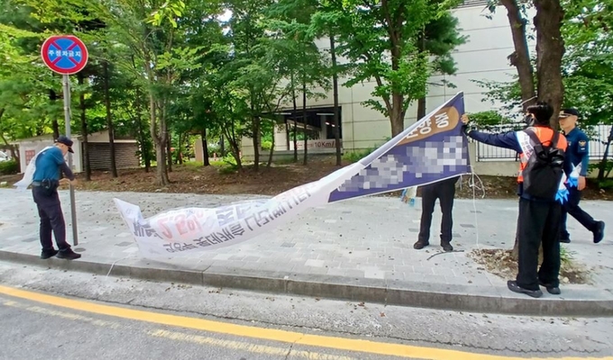불법 옥외광고물 합동 점검반이 금오동 홈플러스 인근 도로변에 설체된 불법 현수막을 제거하고 있다.(사진설명)