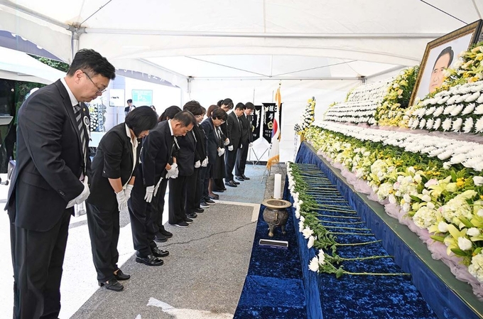 故 오범구 의원의 영결식에 참석한 의정부시의원들이 영정사진 앞에 헌화하고 있다.(사진설명)