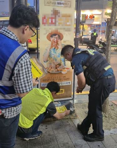 의정부시 공무원과 경찰이 고산동 상업지역에서 합동으로 불법 입간판을 단속하고 있다.(사진설명)