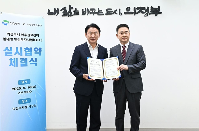 김동근 의정부시장(왼쪽)이 김명구 의정부맑은물주식회사 대표와 협약 체결 후 기념촬영하고 있다.(사진설명)