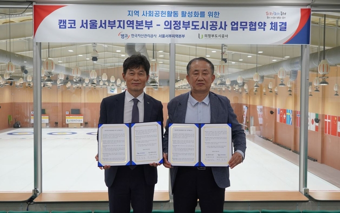 김장호 의정부도시공사 경영사업본부장(오른쪽)과 조성각 한국자산관리공사 서울서부지역본부장(왼쪽)이 지난달 30일 협약체결 후 기념촬영하고 있다.(사진설명)